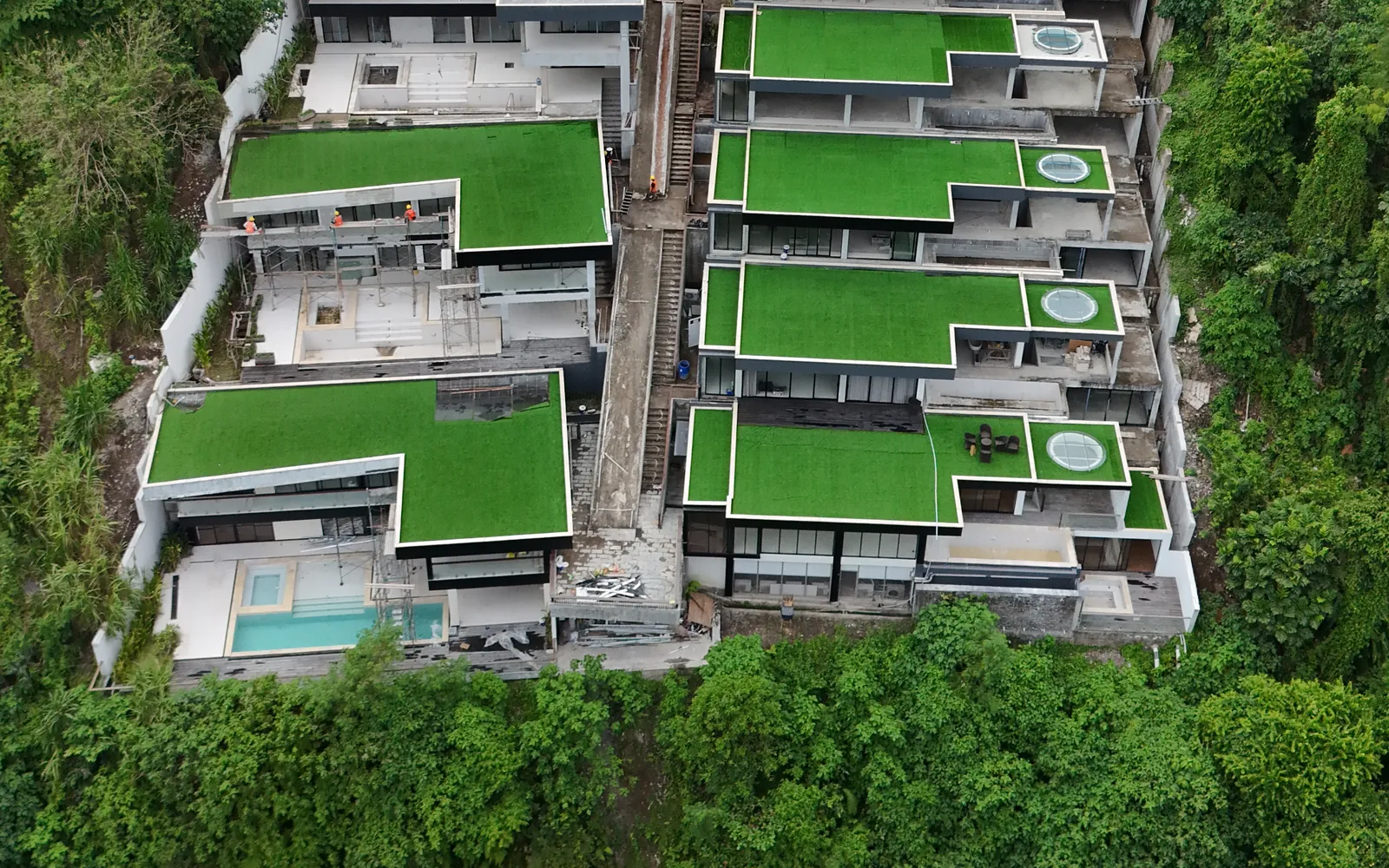 The two rows of residences, with green roofs and private pools.